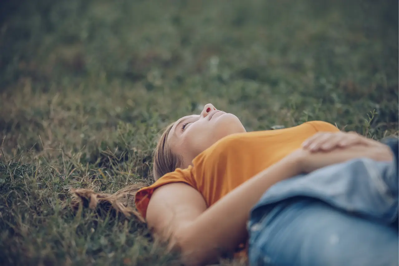 Eine Frau liegt entspannt im Gras